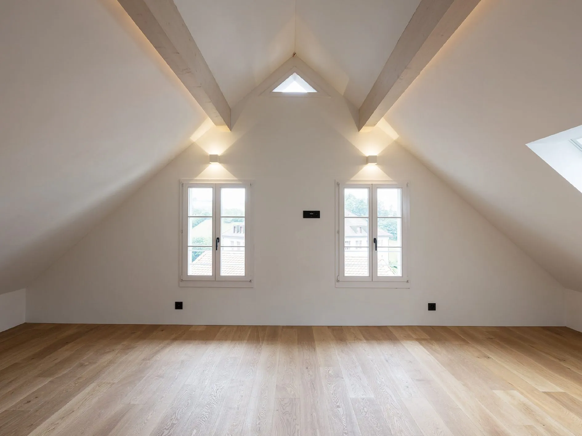 Dachzimmer mit Holzbalken und Eichenboden