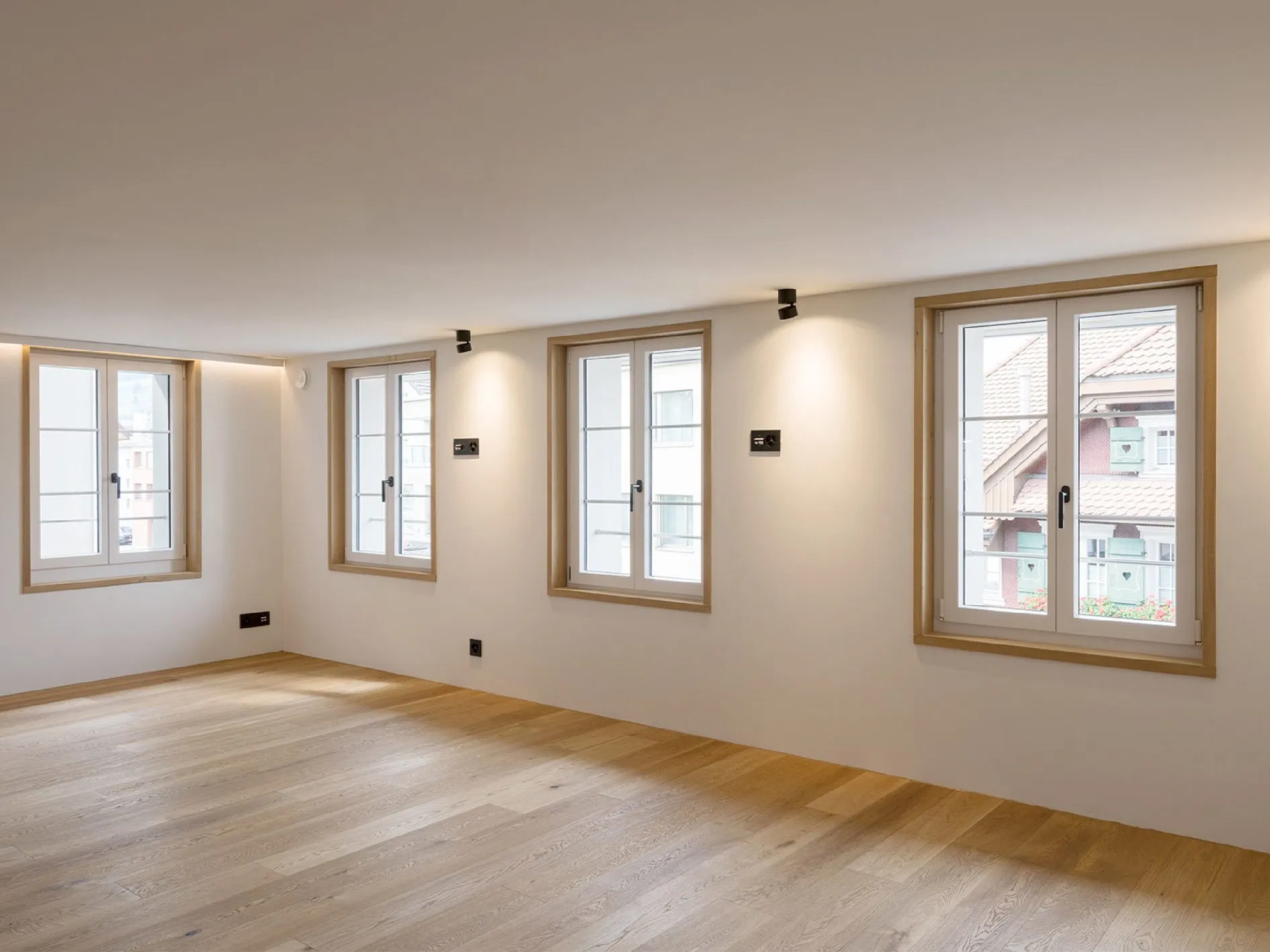 Helles Zimmer mit Holzfenstern und Eichenparkett